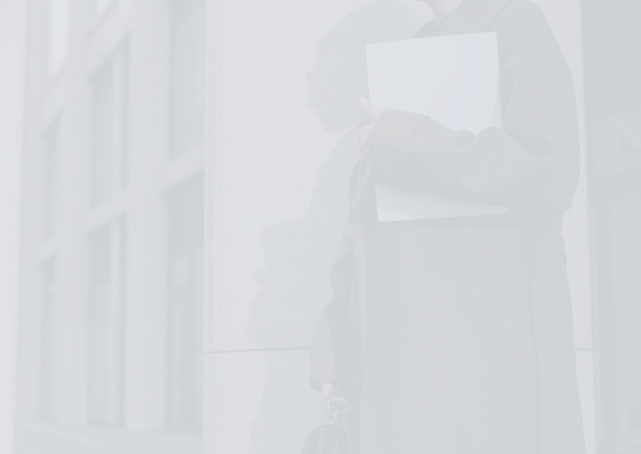 person holding documents in front of building